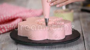糕点厨师正在做一个粉红色的蛋糕，形状像一朵花。 系列。